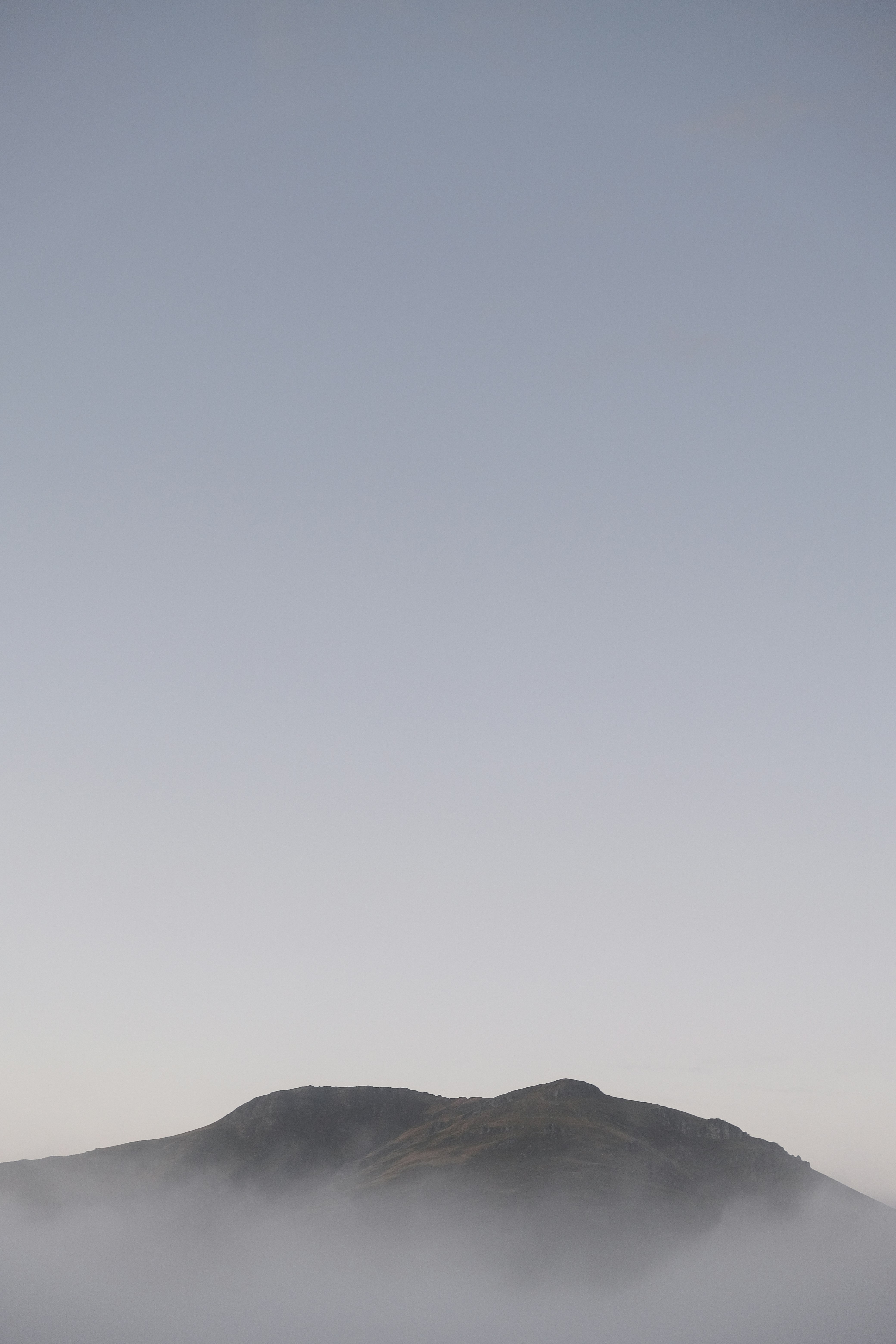 silhouette of mountain under white sky during daytime